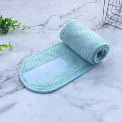 Light blue soft fabric beauty headbands for women rolled on marble surface