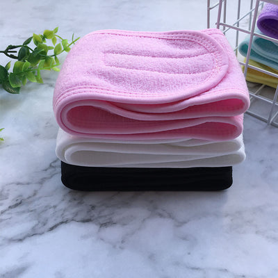 Stack of soft pink white and black beauty headbands for women folded on marble surface