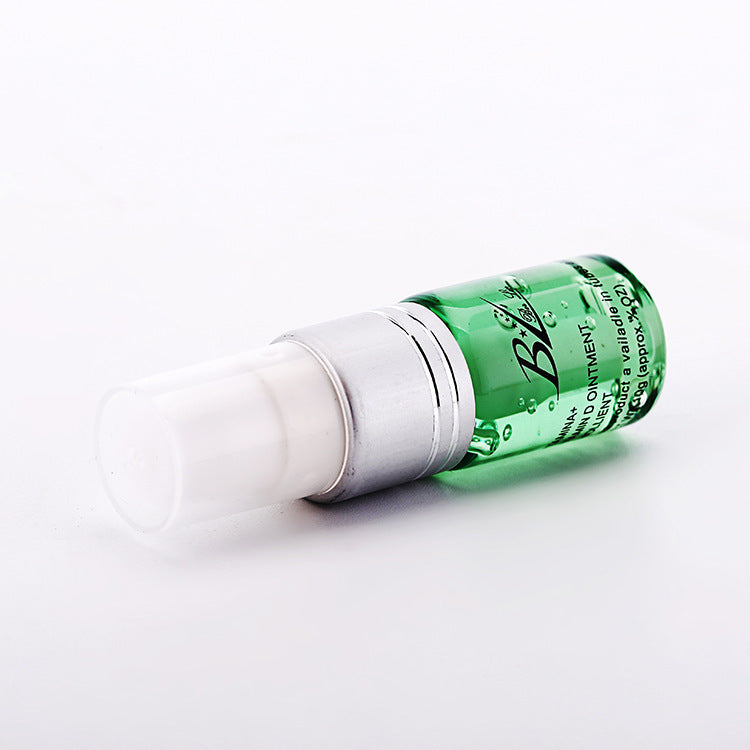Green bottle cosmetic product featuring blue light acne device for skincare treatment