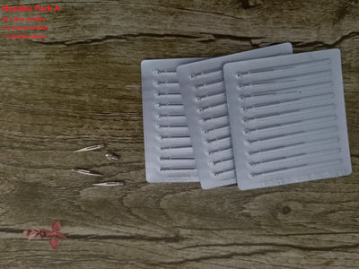 Pack of fine and coarse needles laid on a wooden surface, accessories for blue light acne device