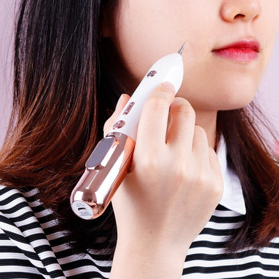 Woman using a white and rose gold blue light acne device on her face for clear skin treatment