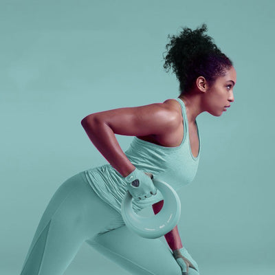 Woman exercising with light blue women's fitness dumbbells wearing matching workout outfit and gloves