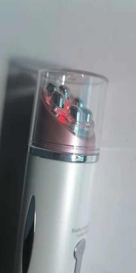 Heated eye massager device with metallic massage nodes and transparent protective cover