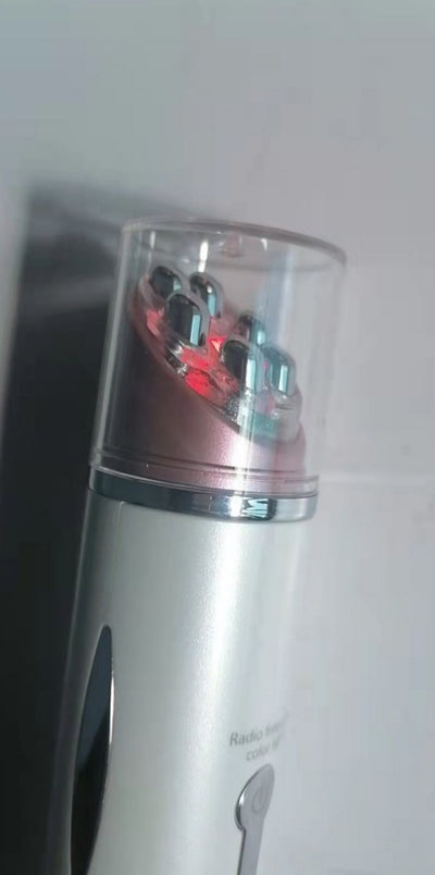 Heated eye massager device with metallic massage nodes and transparent protective cover