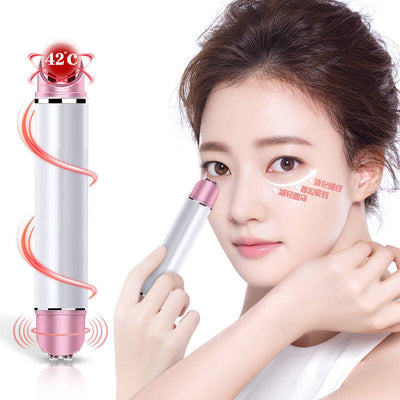 Woman using heated eye massager device near her eye to reduce puffiness and improve skin
