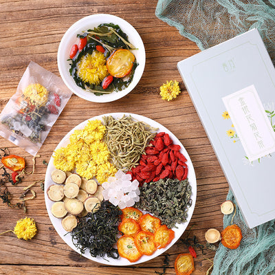 Assorted honeysuckle chrysanthemum tea ingredients displayed on a white plate with dried flowers and herbs