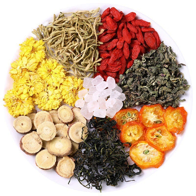 Assorted dried herbs and flowers arranged on a plate for honeysuckle chrysanthemum tea blend