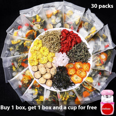 Thirty packs of honeysuckle chrysanthemum tea with assorted dried herbs and fruit on a black background