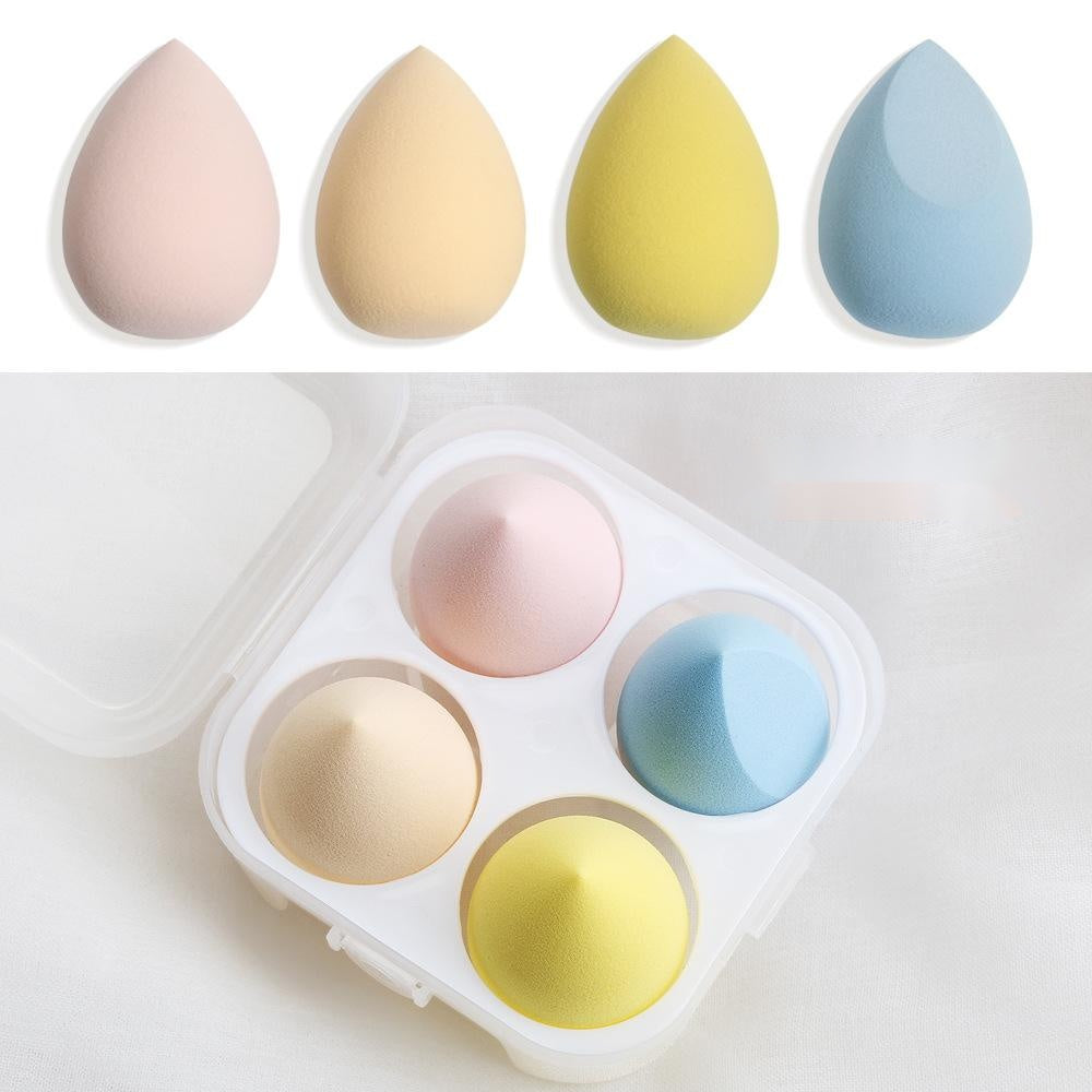 Set of four colorful spherical makeup sponges in pastel pink yellow blue and beige with storage case