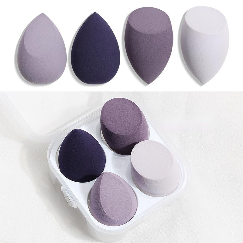 Set of four purple and white spherical makeup sponge applicators with storage case for blending foundation
