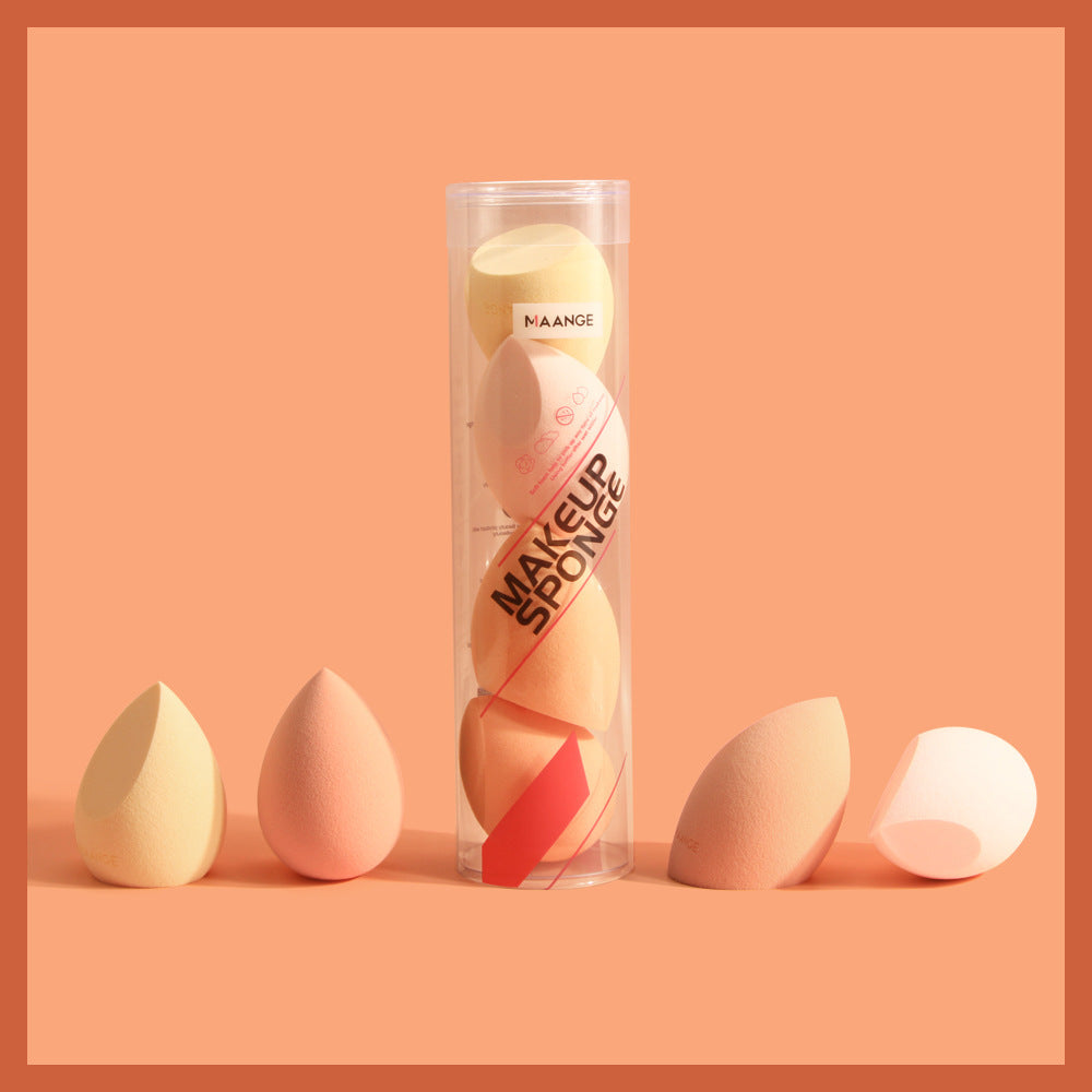 Set of beige and peach spherical makeup sponge applicators in clear cylindrical packaging