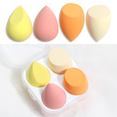 Set of four colorful spherical makeup sponge beauty blenders in yellow pink orange and cream with storage case