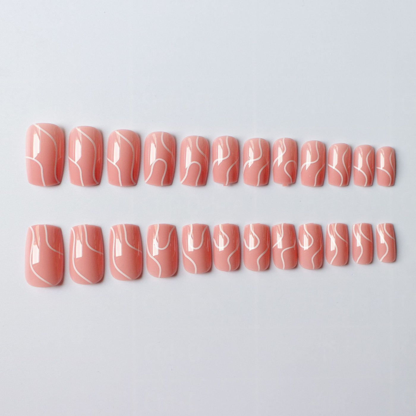 Set of peach press on nails for women with white abstract line designs in two rows