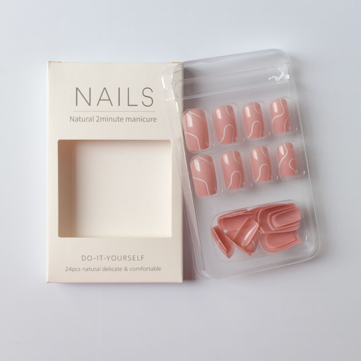 Natural pink press on nails for women with white abstract design in clear packaging beside white box