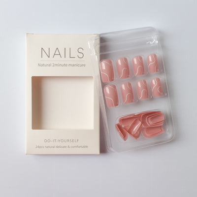 Natural pink press on nails for women with white abstract design in clear packaging beside white box