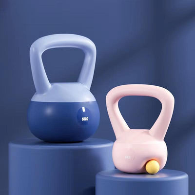 Blue and pink women's kettlebell for home workouts with ergonomic handles on blue pedestals